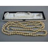 A TRIPLE STRAND ARTIFICIAL PEARL NECKLACE with orb clasp decorated zircons with matching bracelet