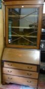 AN EDWARDIAN MAHOGANY AND CROSSBANDED BOOKCASE BUREAU having a scrolled pediment over a single