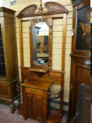 A REPRODUCTION MAHOGANY MIRRORED HALLSTAND with broken top pediment and bevelled central mirror with