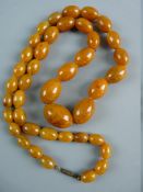 A GRADUATED AMBER BEAD NECKLACE with screw-in clasp, forty one in total, 3 cms the largest, 78 cms