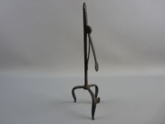 AN 18th CENTURY TRIPOD IRON RUSH LIGHT HOLDER opening via a simple spring to the column, 28 cms