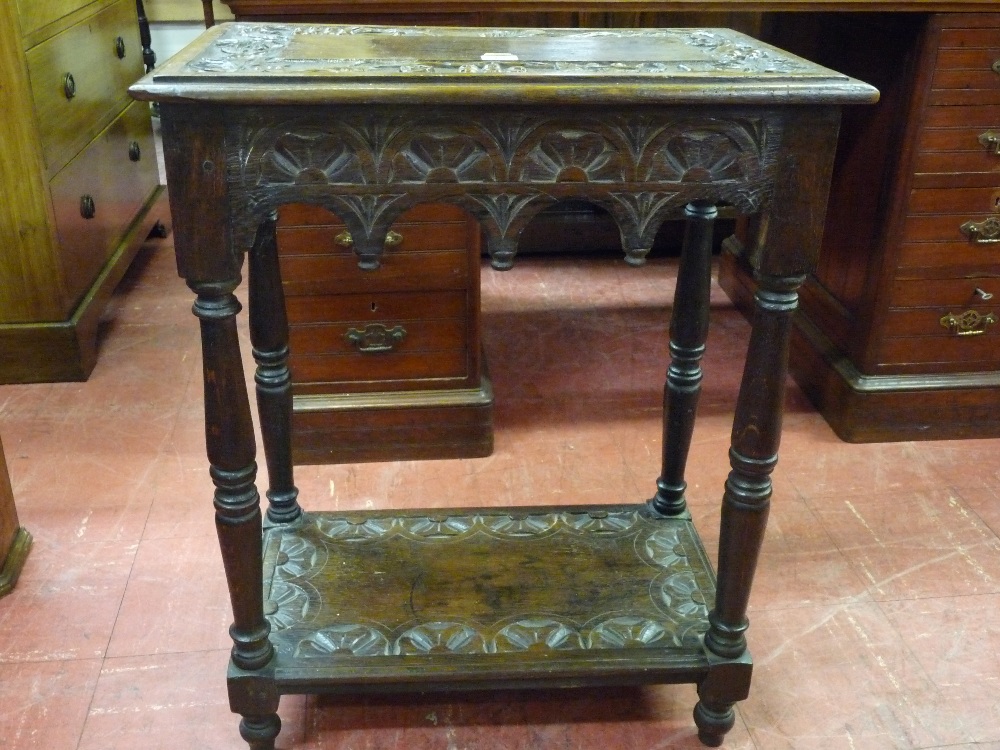 A CARVED OCCASIONAL TABLE, two tier with carved fruit border and carved lunettes to the base