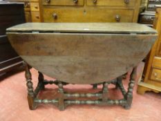 AN 18th CENTURY OAK OVAL TOPPED DROP LEAF GATE LEG DINING TABLE on turned and block supports and