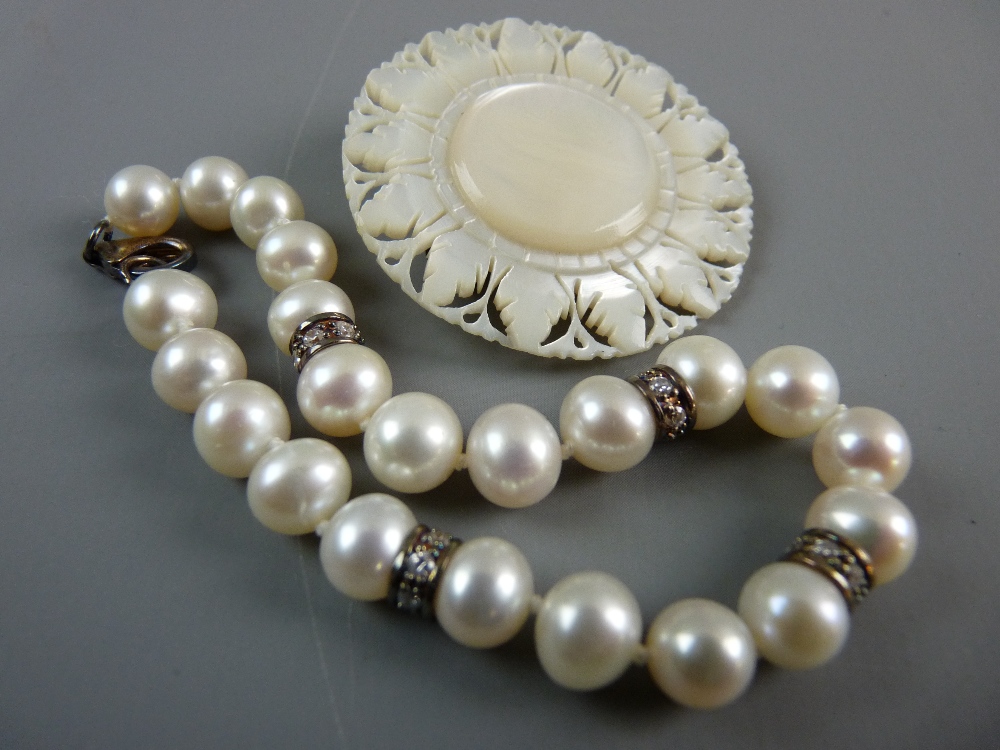 A PEARL BRACELET with four tiny diamond links every four beads and a circular mother of pearl