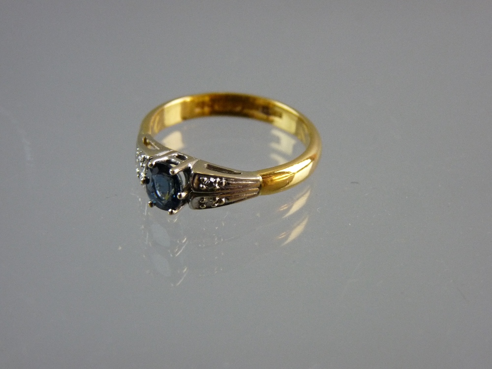 A TWENTY TWO CARAT GOLD DRESS RING with centre oval sapphire and tiny flanking diamonds on double