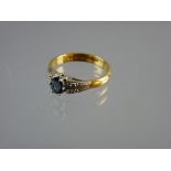 A TWENTY TWO CARAT GOLD DRESS RING with centre oval sapphire and tiny flanking diamonds on double