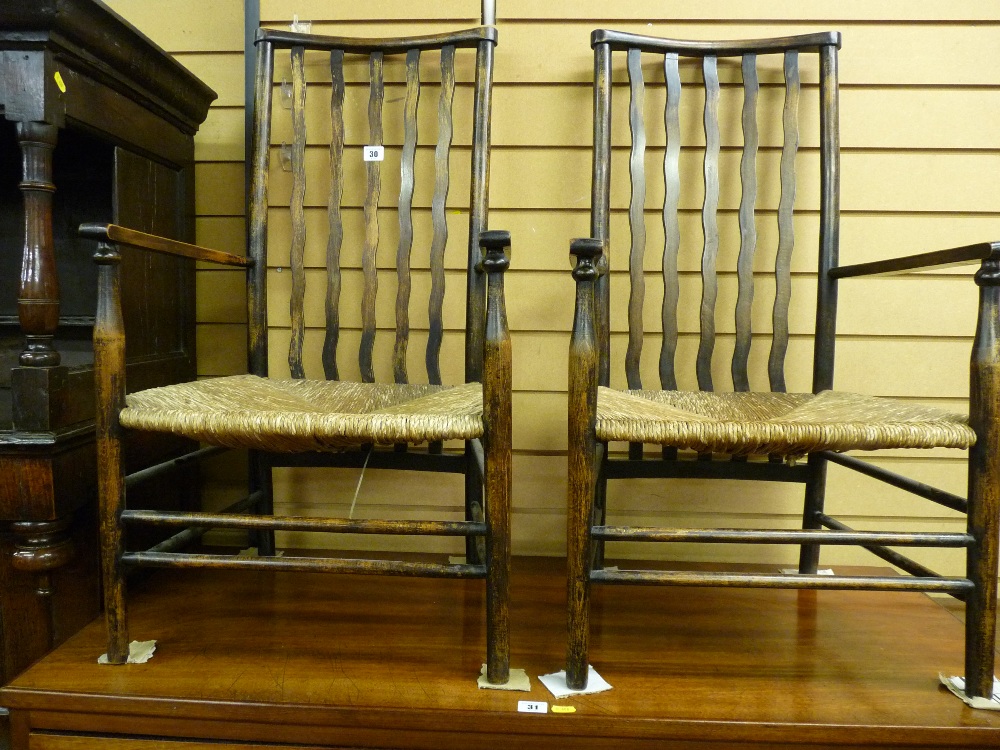 A PAIR OF 19th CENTURY ASH FARMHOUSE ARMCHAIRS with rush seats, wavy slatbacks and turned spindle