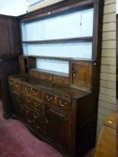 AN EARLY 19th CENTURY OAK WELSH DRESSER, the rack having reeded end columns to a small cupboard at
