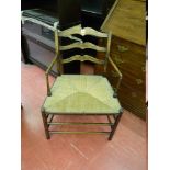 A SIMPLE WIDE RUSH SEATED ELM LADDERBACK ELBOW CHAIR with turned front and side stretchers and