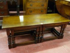 A NEST OF THREE WELL COLOURED RUSTIC STYLE COFFEE TABLES being a Long John table, 106 cms long and a