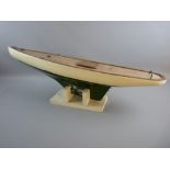 A VINTAGE POND YACHT HULL on stand, clinker built with green and white livery and lead keel (no mast