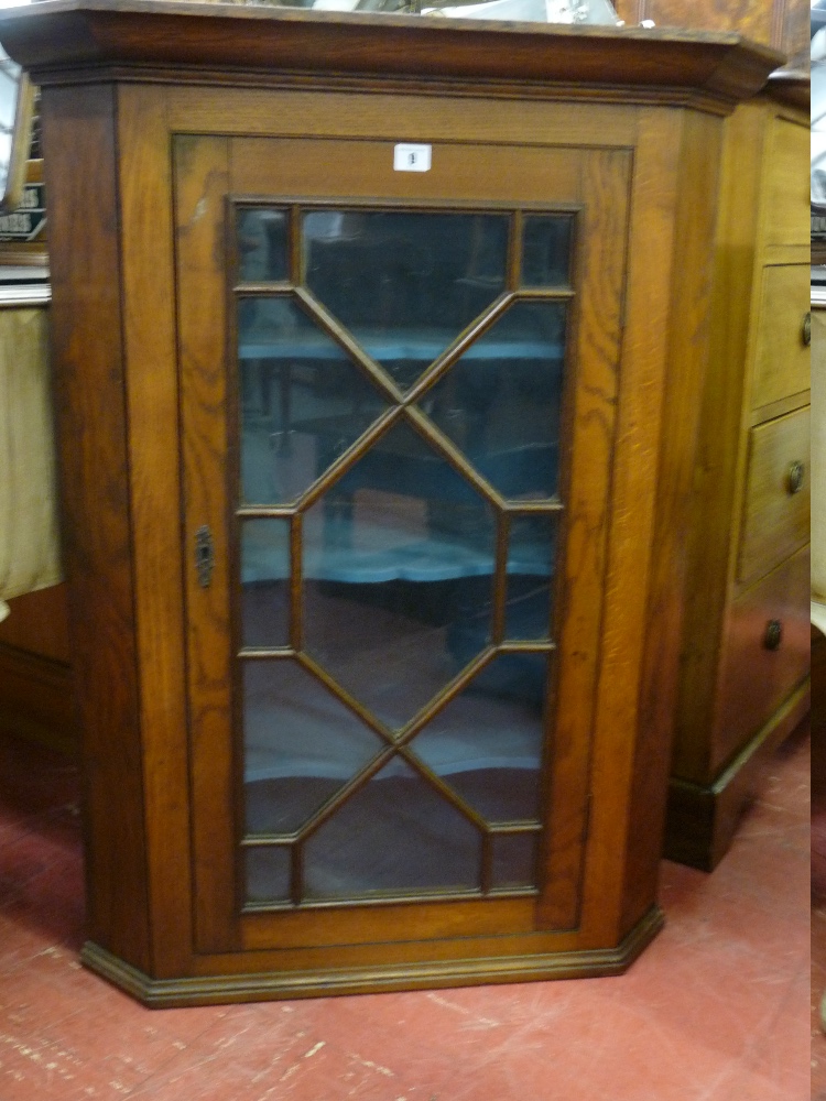 AN ANTIQUE OAK HANGING CORNER CUPBOARD having a single door with astragal panes