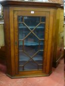 AN ANTIQUE OAK HANGING CORNER CUPBOARD having a single door with astragal panes