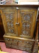 A 19th CENTURY CARVED OAK TWO PIECE PRESS CUPBOARD, the upper section having twin doors with