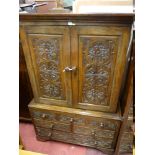 A 19th CENTURY CARVED OAK TWO PIECE PRESS CUPBOARD, the upper section having twin doors with