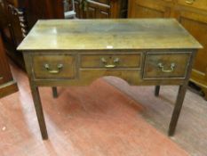 AN EARLY 19th CENTURY OAK LOWBOY having a slim twin plank top over three frieze drawers with central