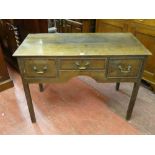 AN EARLY 19th CENTURY OAK LOWBOY having a slim twin plank top over three frieze drawers with central
