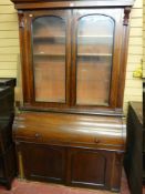 A VICTORIAN MAHOGANY BOOKCASE BUREAU having two glazed upper doors, a centre cylinder top bureau