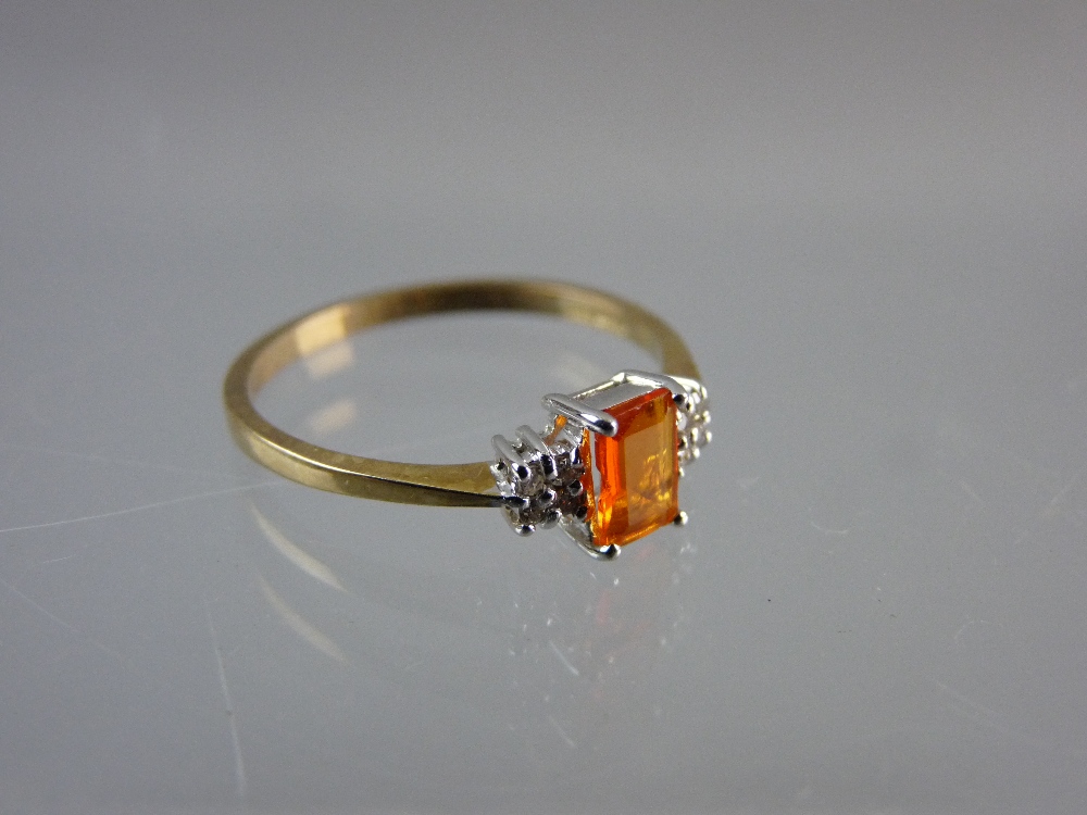 A NINE CARAT GOLD DRESS RING having a centre oblong cut 'fire opal' with flanking diamonds, 1.5