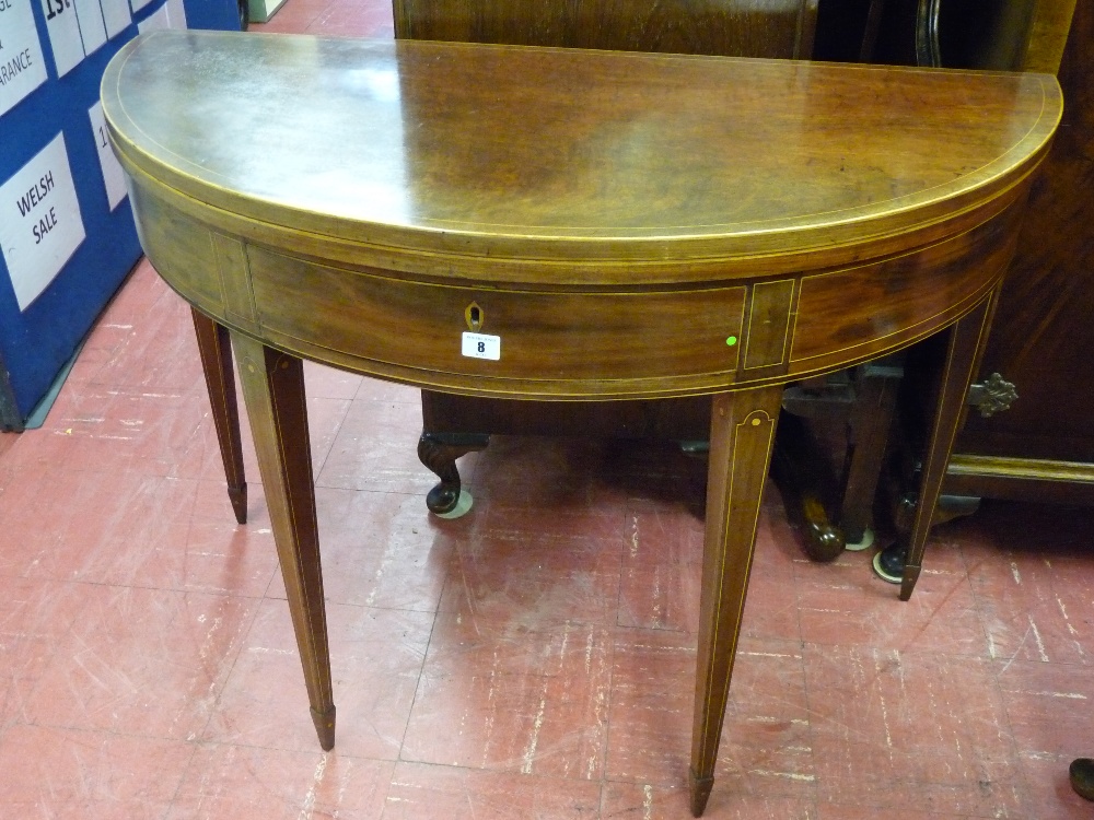 A GEORGIAN MAHOGANY HALF MOON FOLDOVER TEA TABLE, string inlaid on square tapered supports