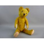 A VINTAGE MOHAIR TEDDY BEAR, gold colour and straw filled with moveable head and limbs, with