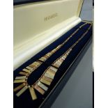 A NINE CARAT GOLD TRIPLE COLOUR NECKLET of graduated oblong tablets, 7.5 grms gross (in an H