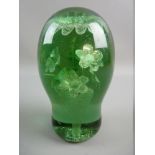 A LARGE VICTORIAN GREEN GLASS DUMP PAPERWEIGHT with interior flowers in a vase design and rough