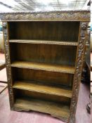 A CARVED OAK FOUR SHELF BOOKCASE, open fronted with lunette and floral decoration, 83 cms wide