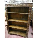 A CARVED OAK FOUR SHELF BOOKCASE, open fronted with lunette and floral decoration, 83 cms wide