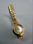 A LADY'S NINE CARAT GOLD ENCASED CIRCULAR DIAL REGENCY WRISTWATCH with expanding stainless steel and