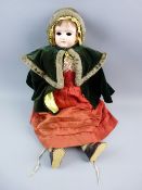 A BISQUE HEADED SHOULDER PLATE DOLL in original clothing, circa 1900 with painted eyebrows and