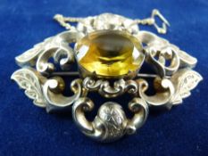 A LARGE PINCHBECK OVAL SCROLLED BROOCH with centre amber coloured stone, 10.3 grms