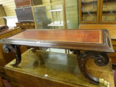 AN EMPIRE STYLE REPRODUCTION COFFEE TABLE with tooled leather top on curved carved supports with