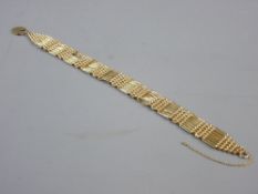 A NINE CARAT GOLD SEVEN BAR BOW BASKET BRACELET and padlock with safety chain (one bar missing