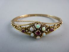 A NINE CARAT GOLD OPAL AND RUBY BRACELET, the bracelet of triple split form with a fine floral