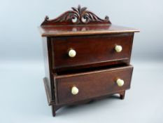 A REPRODUCTION MAHOGANY APPRENTICE STYLE CHEST having a pierced and carved top rail on a moulded