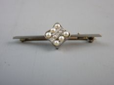 A BELIEVED PLATINUM BAR BROOCH with a centre group of six small pearls and five tiny diamonds, 3.4