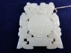 A CARVED AND PIERCED CHINESE JADE PENDANT, decorated with a mythical beast over a four character