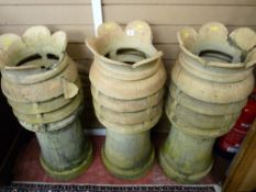 THREE SANDSTONE COLOURED CHIMNEY POTS, 92 cms high, (some losses and cracks)