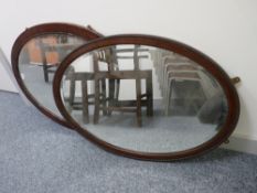 TWO VINTAGE MAHOGANY FRAMED OVAL WALL MIRRORS with bevelled glass and beaded edge decoration, 92 and