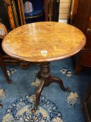 AN ANTIQUE OAK TILT TOP TRIPOD TABLE, the 59 cms diameter top on a carved column with shaped legs