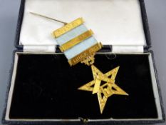 A NINE CARAT GOLD MASONIC PAST MASTER'S PRESENTATION STAR suspended on pale blue ribbon with bars