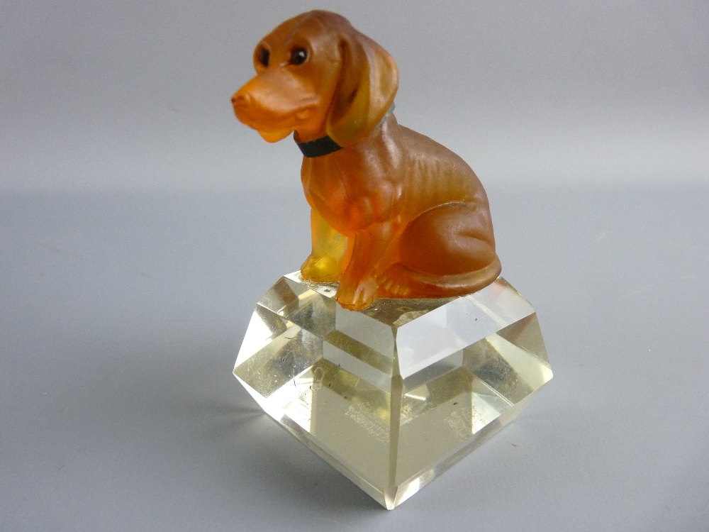 A FROSTED AMBER GLASS MODEL OF A SEATED DOG with inset eyes and a metal collar set upon a facet