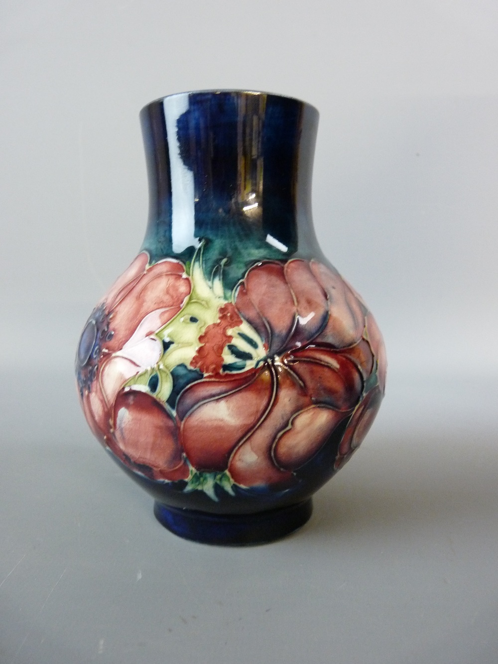 A MOORCROFT ANEMONE BULBOUS VASE, 13 cms high, decorated on a cobalt ground, impressed to the