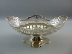 A HALLMARKED SILVER PIERCED PEDESTAL FRUIT BOWL with shaped top edge and open swag decoration on a