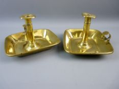 A PAIR OF MATCHING GEORGIAN BRASS CHAMBER STICKS with deep rectangular drip trays, 13 cms high