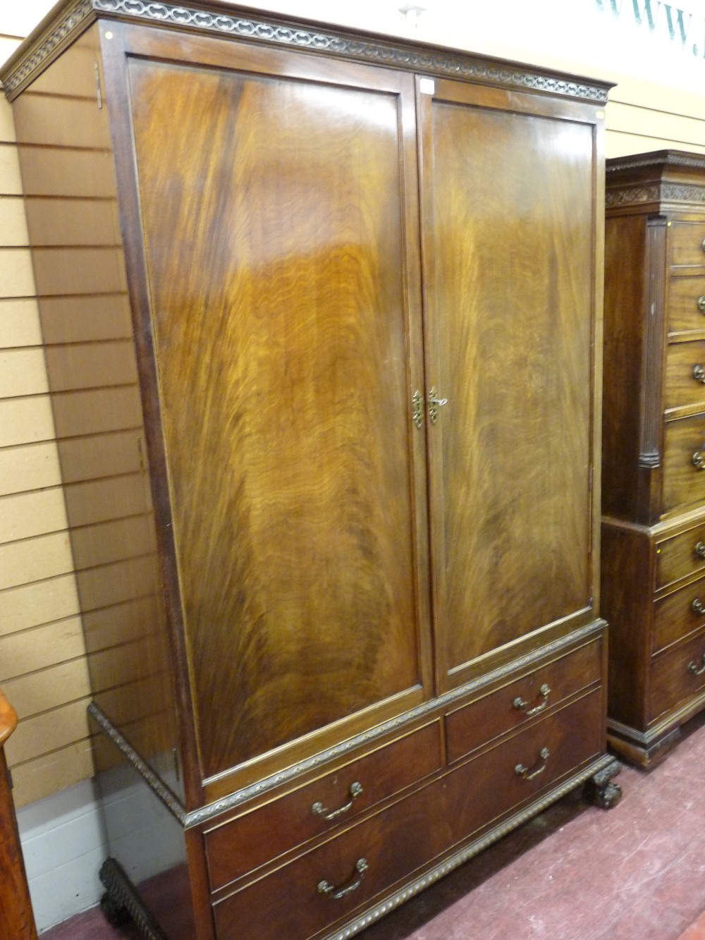 AN EDWARDIAN MAHOGANY COMBINATION WARDROBE with a blind fret cornice over twin opening doors,