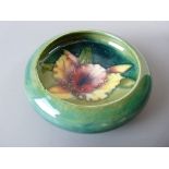A MOORCROFT ORCHID BOWL, 11 cms diameter, decorated on a tonal green ground, impressed to the