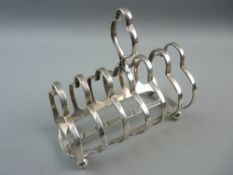 A SILVER SIX COMPARTMENT TOAST RACK on ball supports, 13 troy ozs, Sheffield 1915