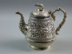 AN INDIAN SILVER TEAPOT with elephant knop lid and chased decorated bird and swag body, 16 x 18 cms,